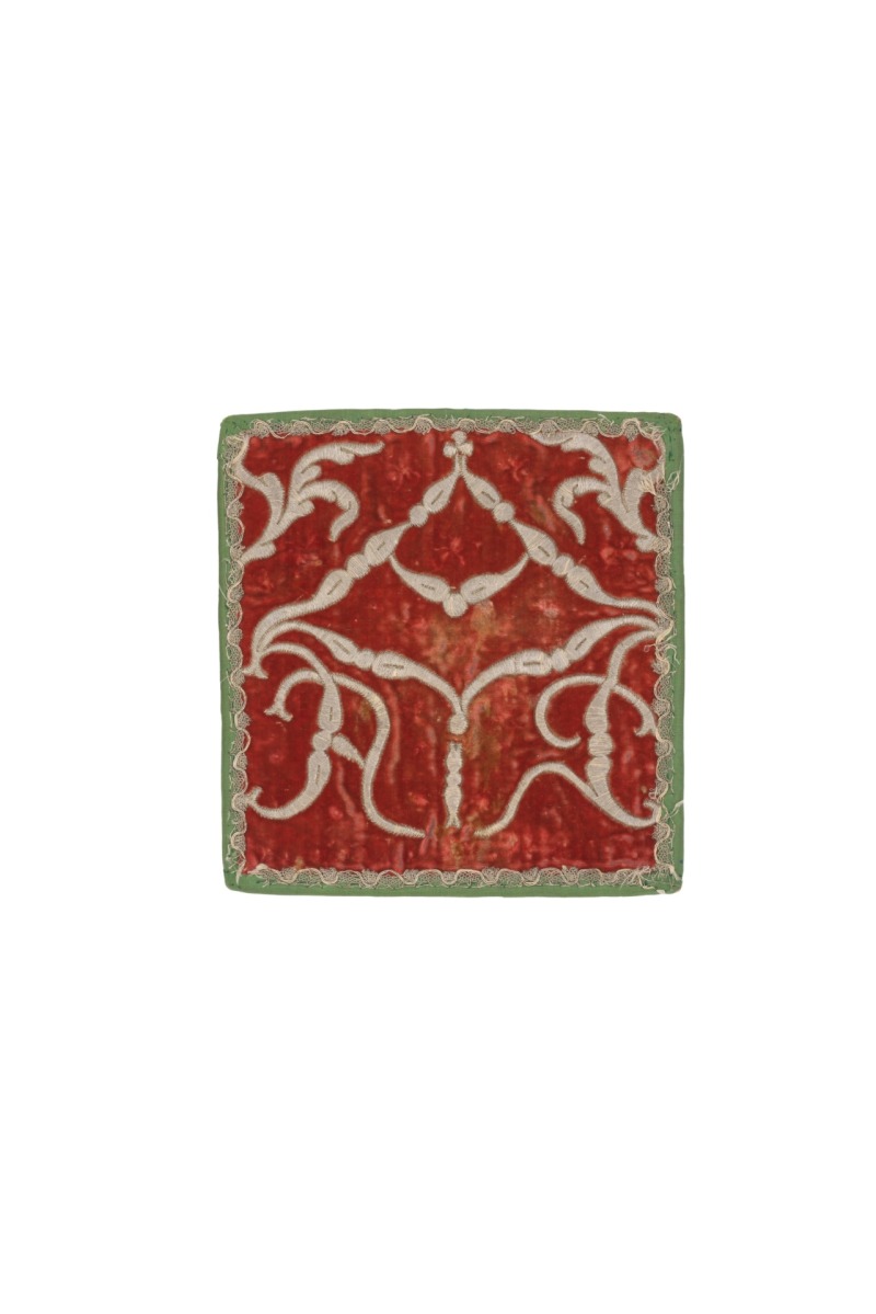 Bursa. Vilniaus benediktinių vienuolyno dirbtuvės, XVIII a. I p. Raudonas šilkinis aksomas, reljefinis siuvinėjimas sidabro siūlais ant vilnonio užtraukimo; vidus – lino drobė; pinikai – sidabro siūlai; apačia ir kraštai apsiūti šilko tafta; 19 x 18 cm. Seserų benediktinių abatija Žarnoviece, B40 (142/B40/2020). Fot. Zofia Grunt, Joanna Szmit