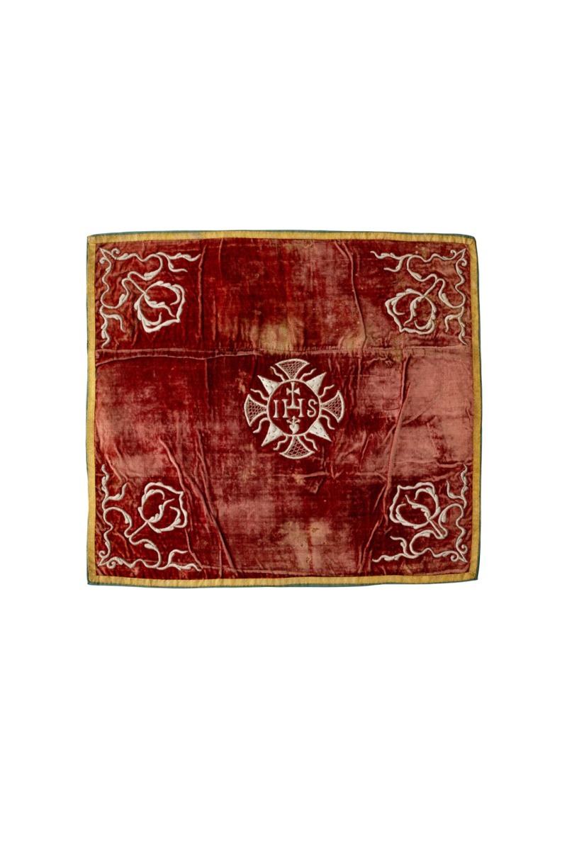 Veliumas. Vilniaus benediktinių vienuolyno dirbtuvės, XVIII a. vid. Raudonas šilkinis aksomas – Prancūzija, XVII a. I p., reljefinis siuvinėjimas sidabro siūlais ant vilnonio užtraukimo; galionai – aukso siūlai; pamušalas – žalias atlasas; 50 x 53 cm. Bažnytinio paveldo muziejus, BT 601/3. Fot. Gediminas Trečiokas